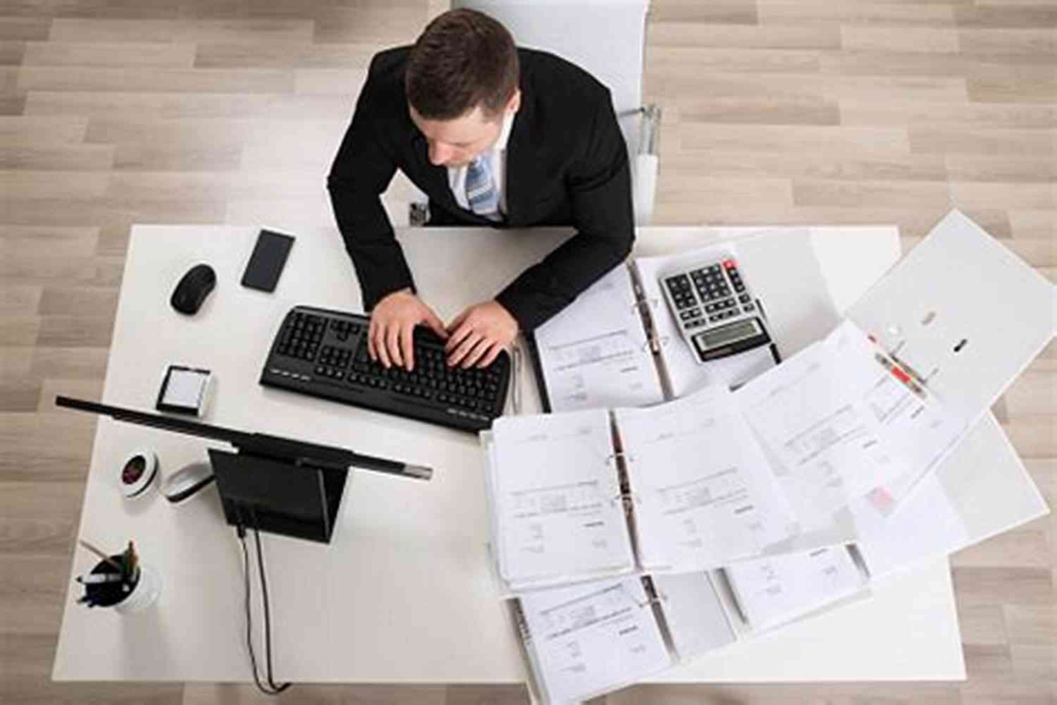 A Businessman Analyzing Data At A Desk TRIR: The Definitive Guide To Understanding Your TRIR And How It Affects Your Business Your Pre Qualification Paperwork And Your ISNetworld Account